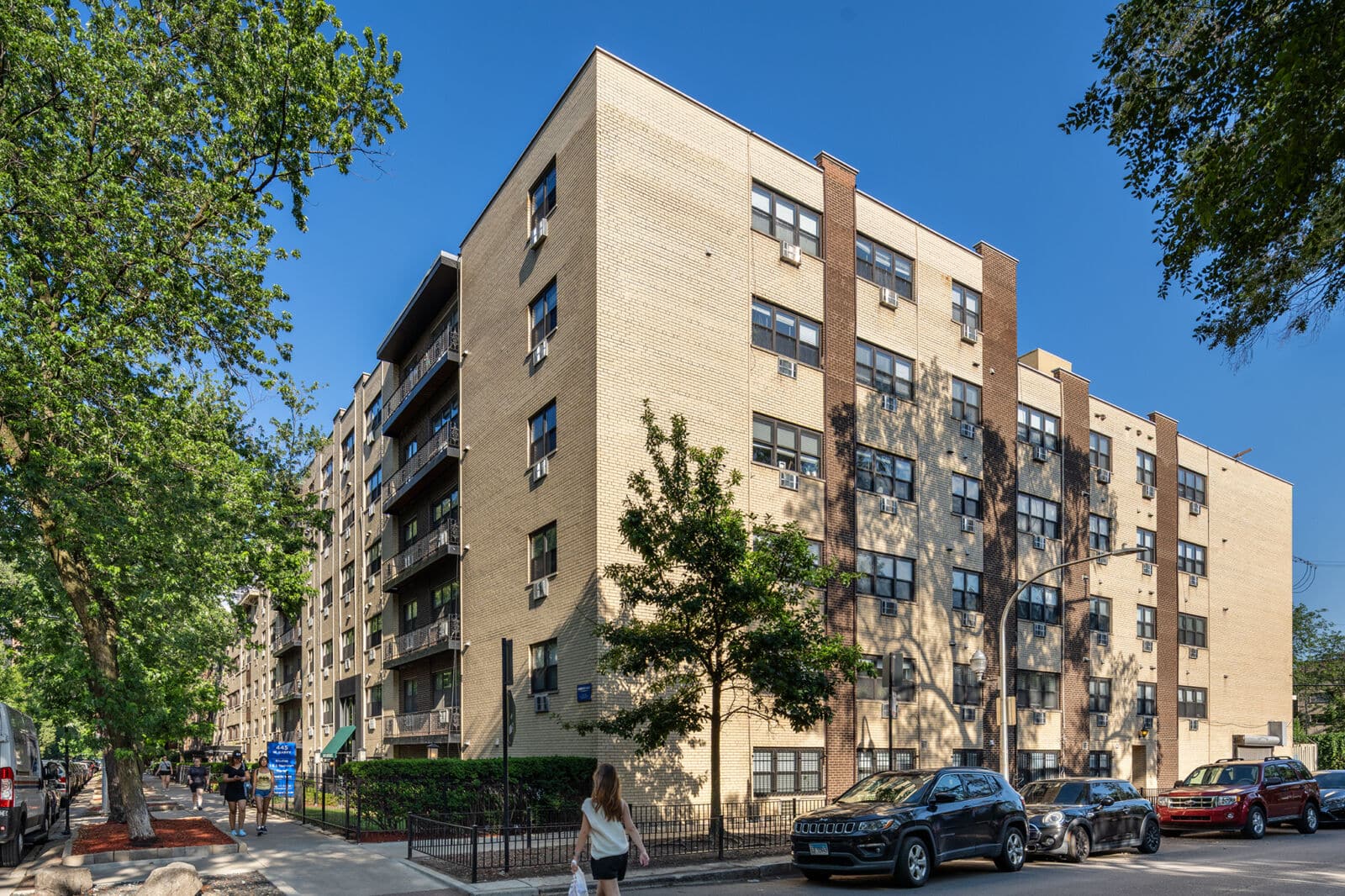 Six-story cream and brown brick apartment building with private balconies at 445 W Barry Avenue i...