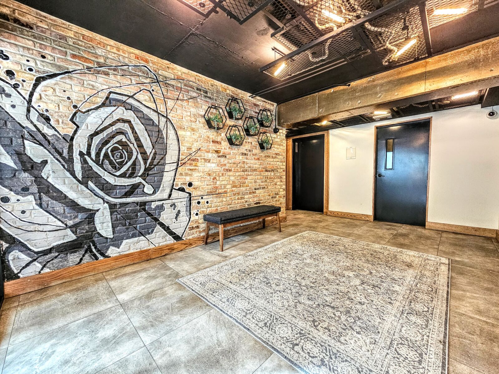 The industrial-style lobby at 528 W Oakdale featuring a large black-and-white rose mural painted ...