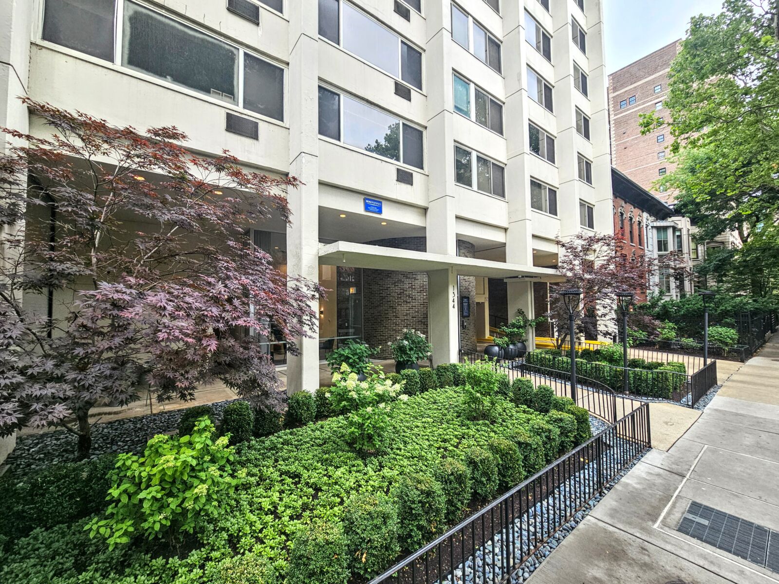 A landscaped path at 1344 North Dearborn leading to the building’s main entrance, bordered by lus...