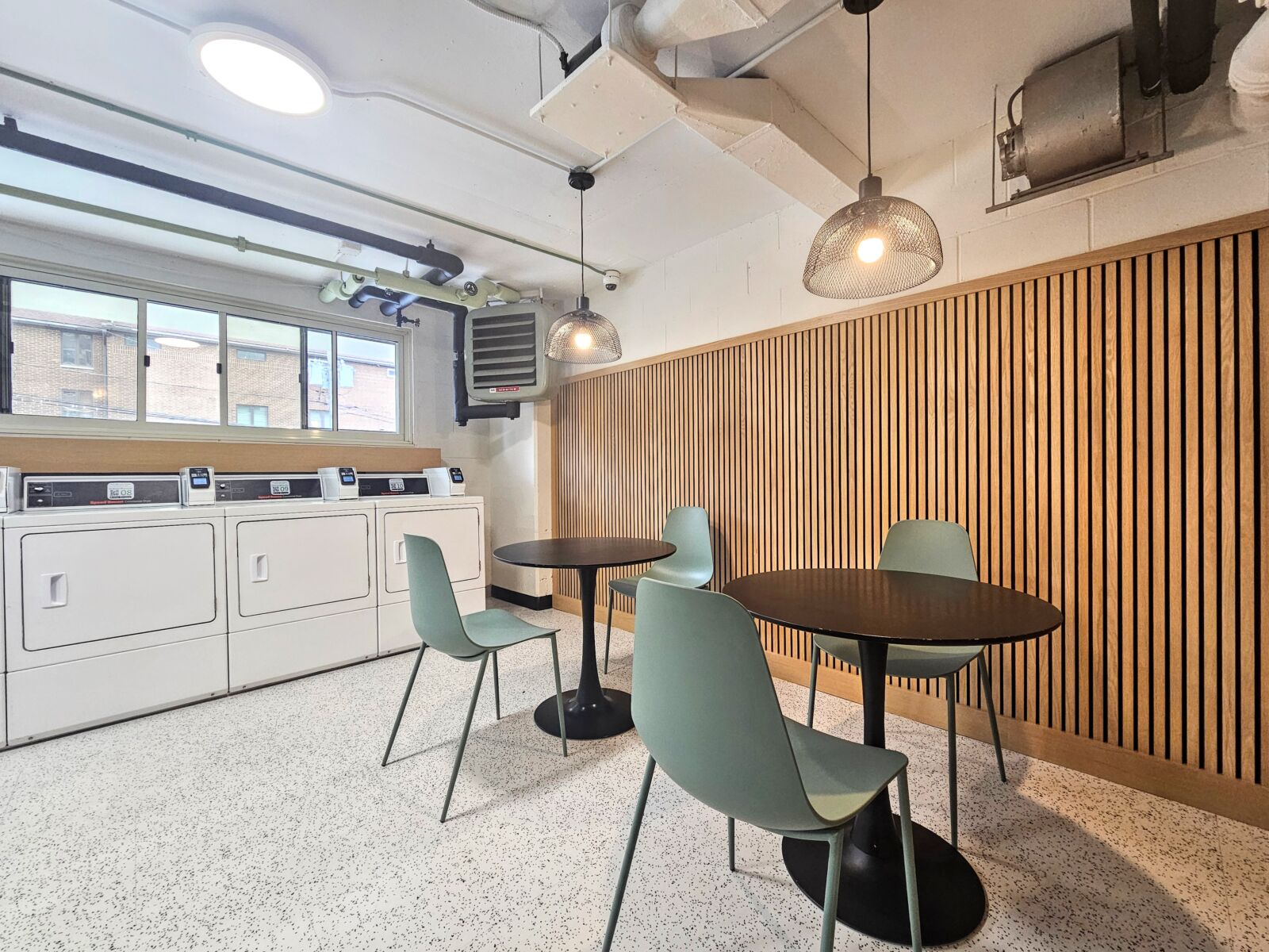 A clean, modern laundry room at 1344 North Dearborn with front-loading washers and dryers along t...