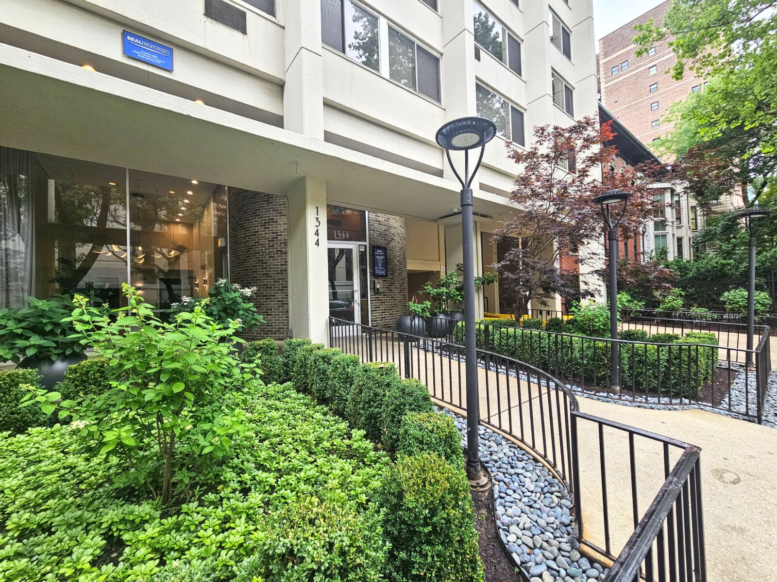 The landscaped front entry of 1344 North Dearborn, with manicured hedges, decorative planters, an...