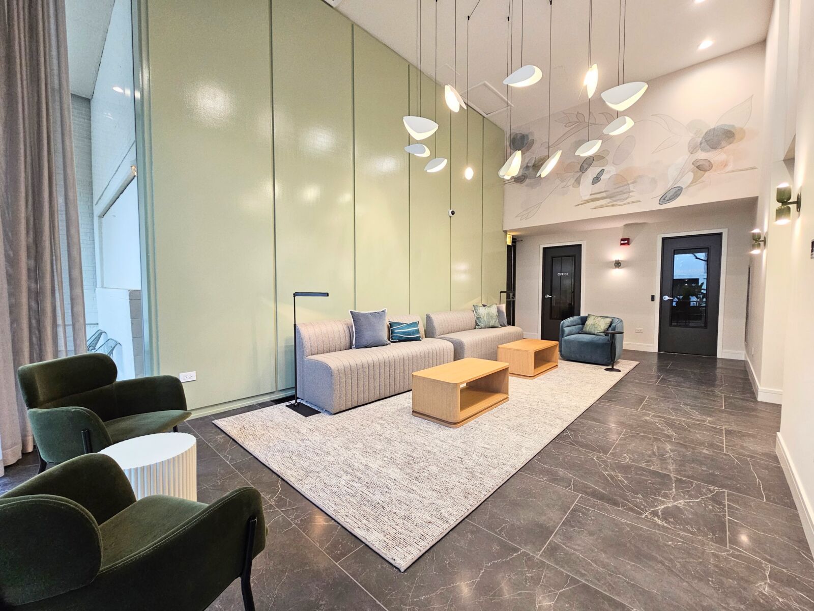 Lobby lounge with vaulted ceilings, soft seating in muted tones, and sculptural pendant lights.