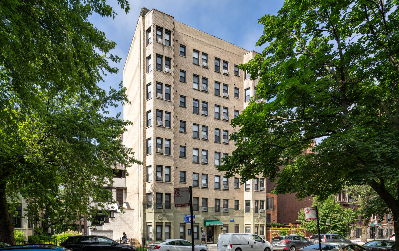 Eight-story beige brick apartment building with green awning at 550 W Arlington Place in Chicago’...