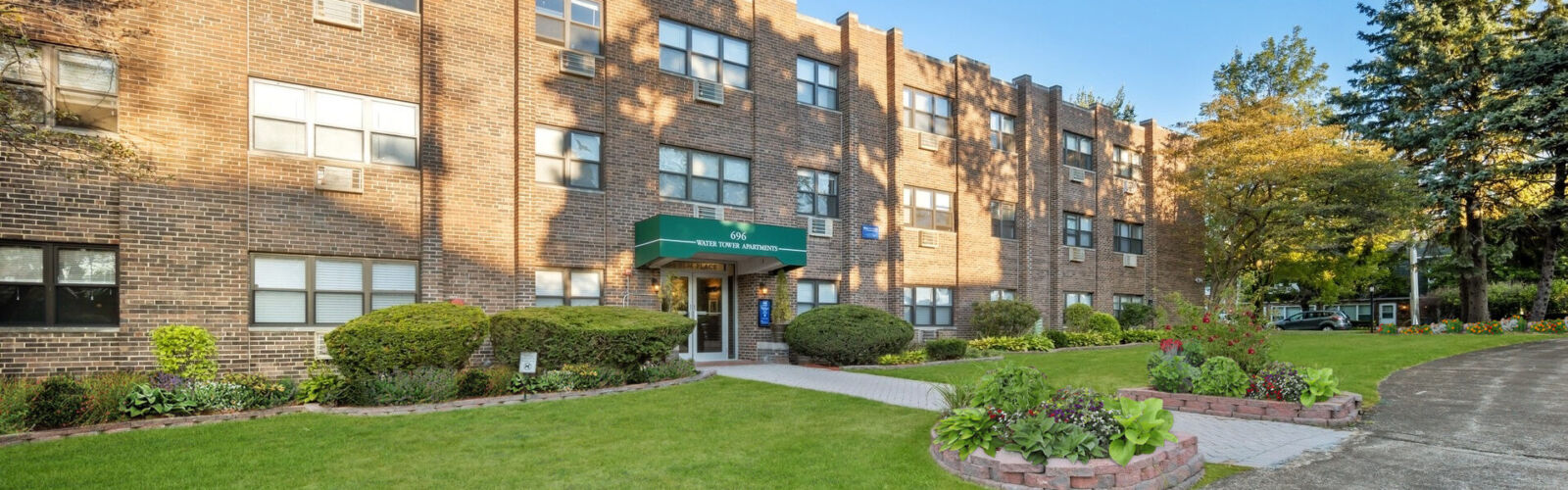 Exterior with red-brick facade and green awning over entry.