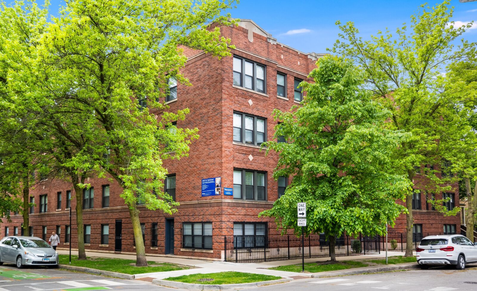 Classic red brick courtyard apartment building with decorative stone accents at the corner of a t...