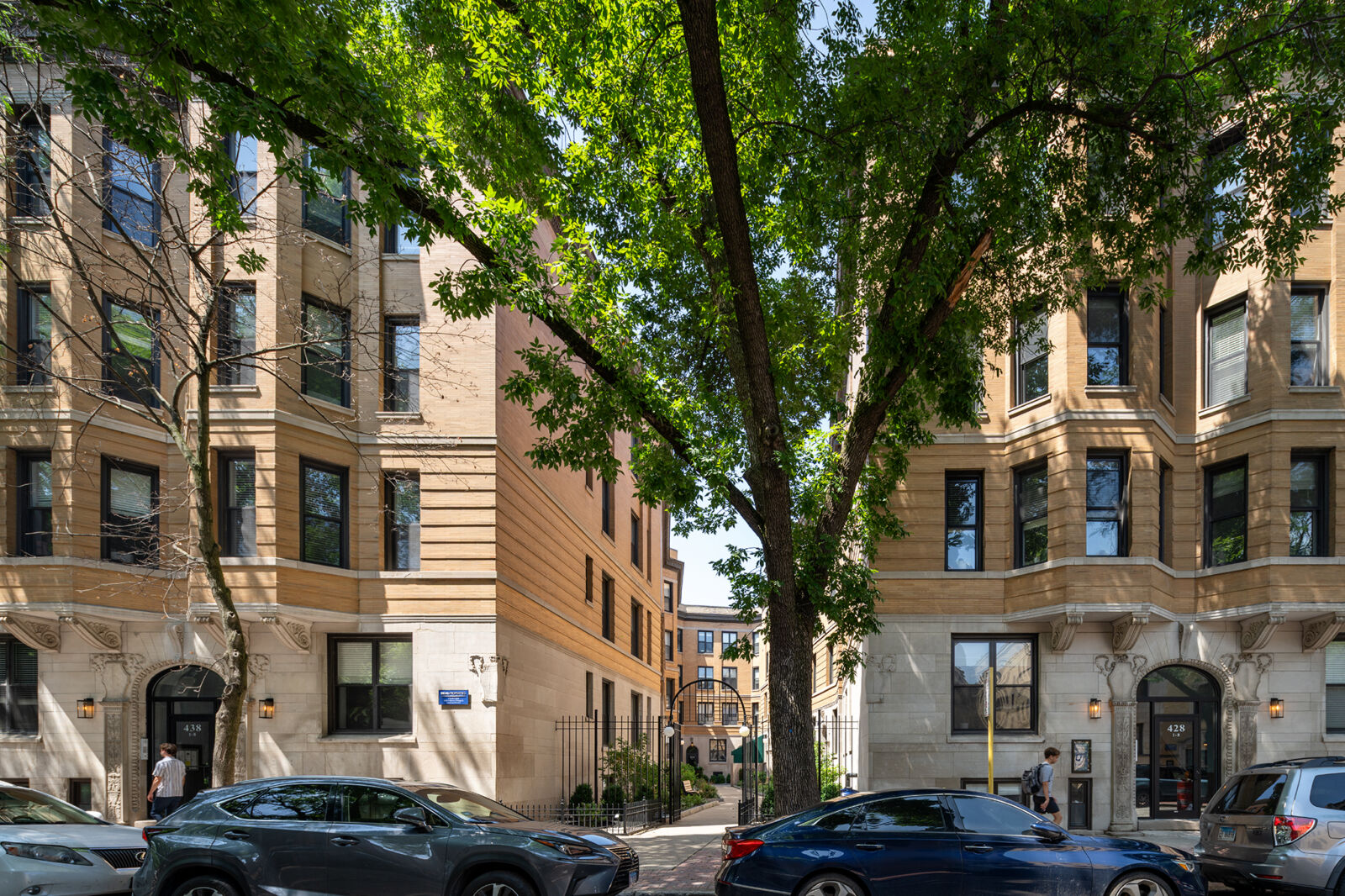 Beige stone courtyard apartment buildings at 428–38 W Belden Avenue in Lincoln Park, with gated e...