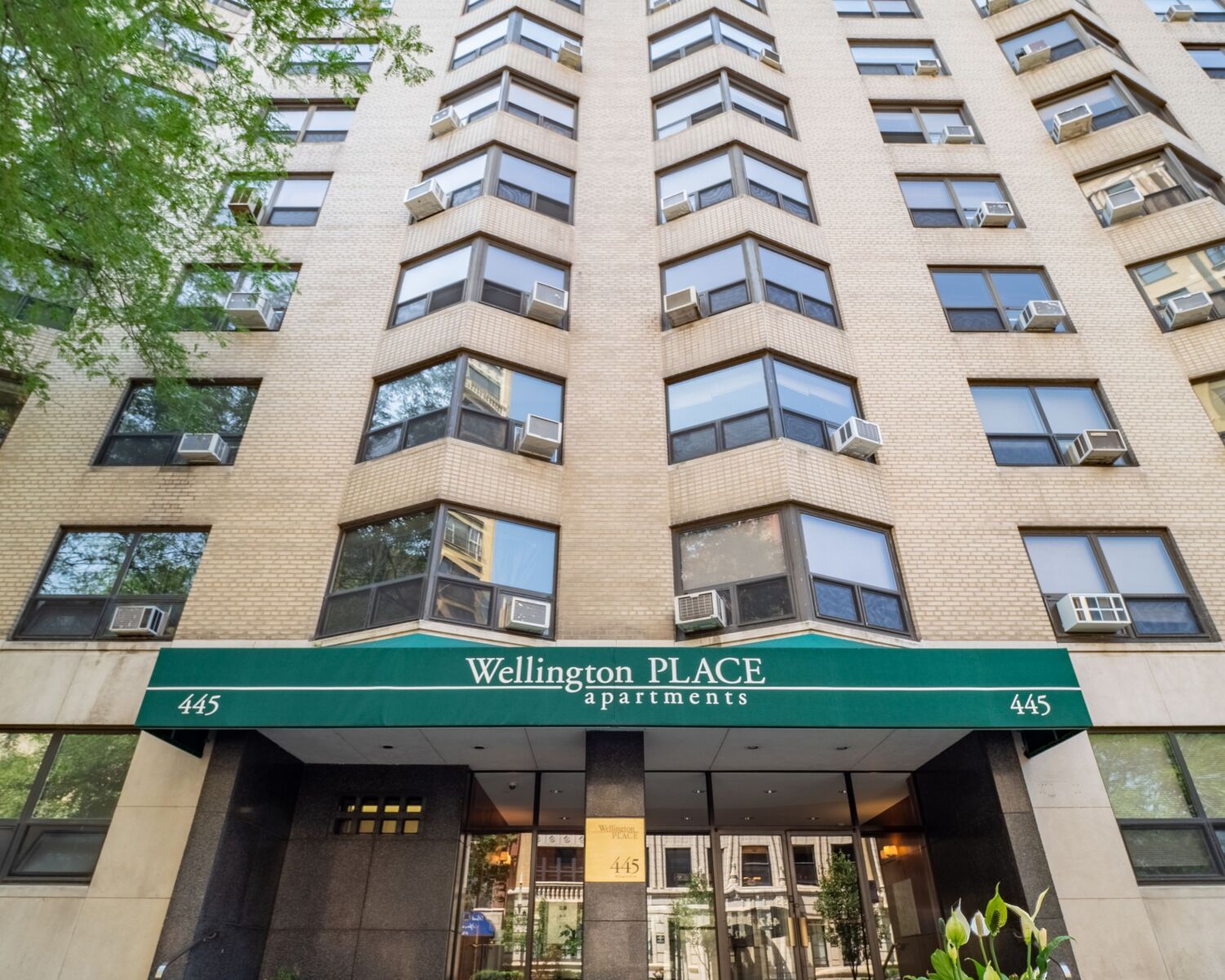 A high rise apartment building at 445 W Wellington in Chicago’s Lakeview neighborhood, with beige...
