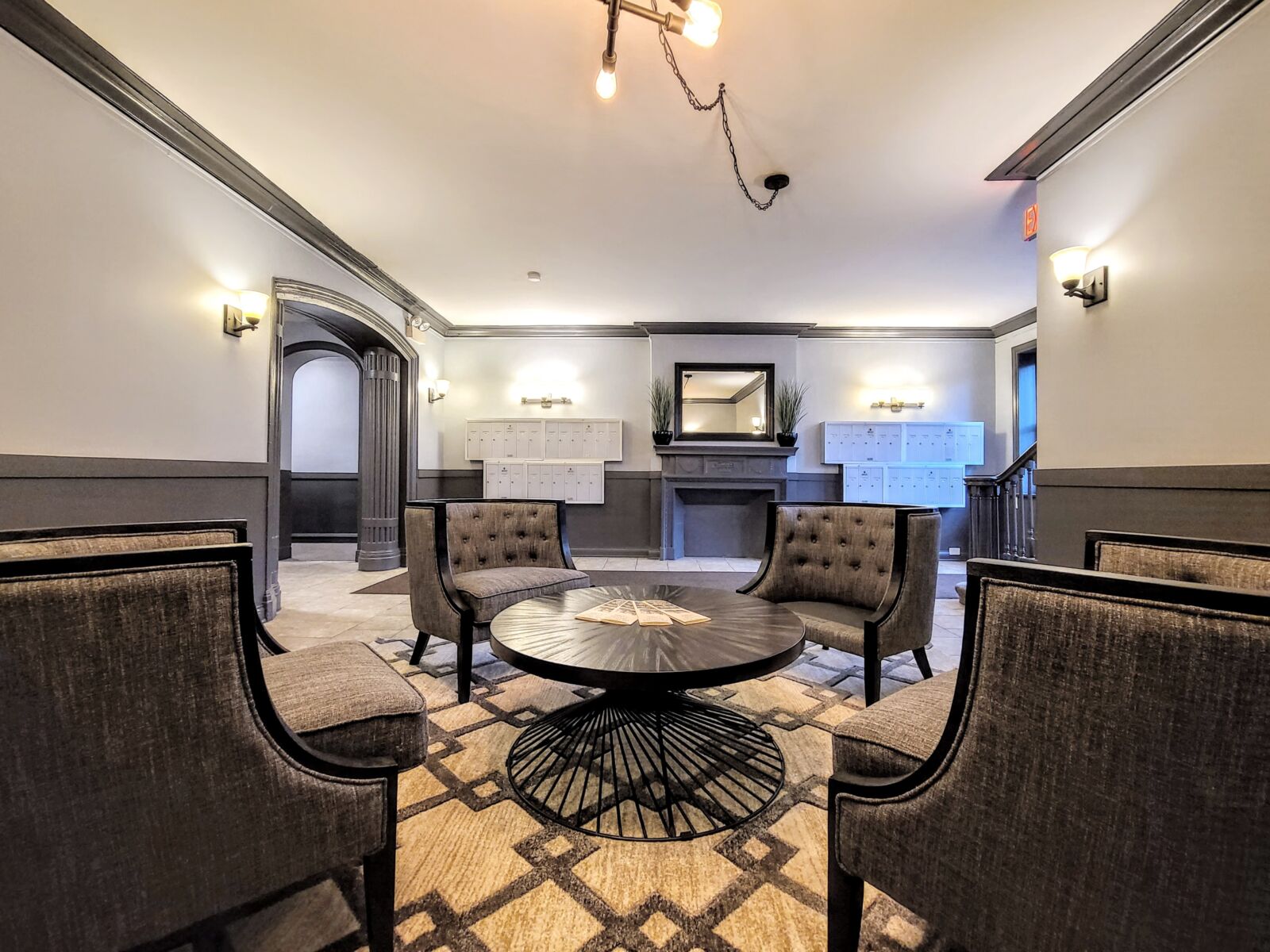 A modern lobby seating area at 837 West Wolfram featuring four gray armchairs, two gray settees, ...
