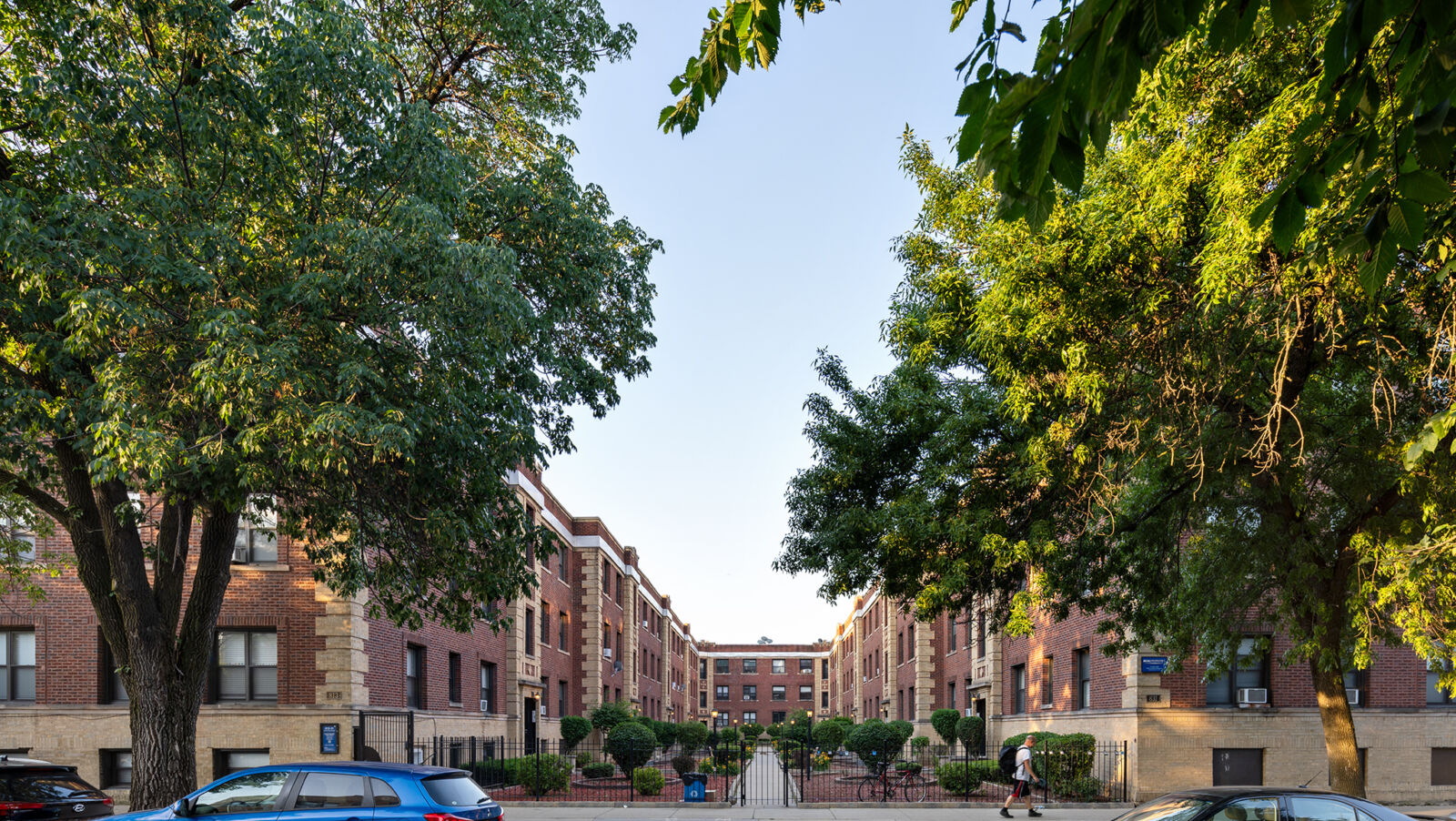 A three-story red and tan brick courtyard building at 813–831 West Waveland in Chicago’s Wrigleyv...